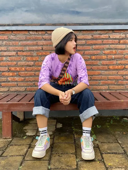Seperti gaya OOTD-nya ini. Pakai kaus ungu dan celana jeans biru dongker, penampilannya kian modis dengan kets putih serta binnie.(Liputan6.com/IG/@fuji_an)