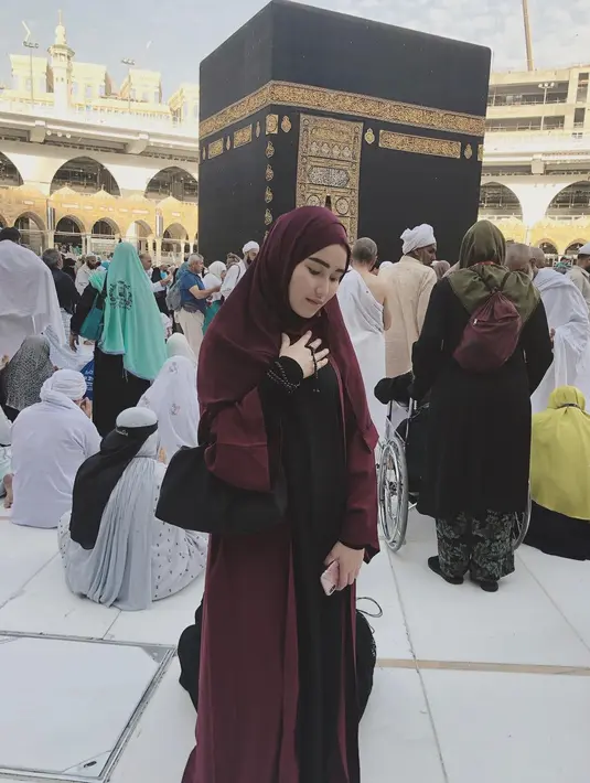 Dalam unggahan Instagramnya, Ayu Ting Ting mengenakan gamis berwarna merah tua serta hijabnya saat berpose di depan Ka'bah, di mana Ia menuliskan "My Baitullah" sebagai caption fotonya.  (Liputan6.com/Instagram/@ayutingting92)