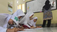 Sejumlah siswa kelas VI  Madrasah Ibtidaiyah Mathlaul Anwar Ciangsana belajar di lantai tanpa meja dan kursi pada bangunan majelis taklim, Tenjolaya, Kabupaten Bogor, Selasa(22/10/2019).  Kegiatan  dilakukan karena dua dari lima ruang kelas yang ada sudah rusak dan lapuk. (merdeka.com/Arie Basuki)