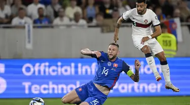 Gelandang Portugal Bruno Fernandes menembak untuk mencetak gol pertama timnya melewati bek  Slovakia Milan Skriniar dalam laga Grup J Kualifikasi Euro 2024 di Stadion Tehelne pole, Bratislava, Sabtu (9/9/2023) dini hari WIB. (AP Photo/Radovan Stoklasa)