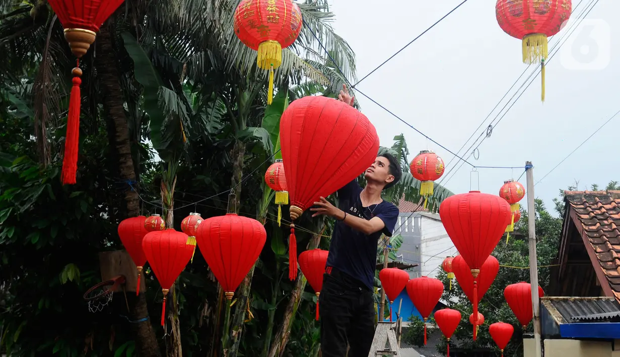 Lampion-lampion dipasang warga di Kampung Haji Bona, Depok, Jawa Barat, Kamis (19/1/2023). Perayaan tahun baru Imlek dimulai pada hari pertama penanggalan Tionghoa yaitu tanggal 22 Januari 2023 dan berakhir pada Cap Go Meh. (merdeka.com/Arie Basuki)