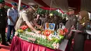 Djarot Saiful Hidayat memotong tumpeng saat upacara hari ulang tahun Satpol PP dan Satuan Perlindungan Masyarakat (Satlinmas) di Jakarta, Kamis (27/4). (Liputan6.com/Gempur M. Surya)