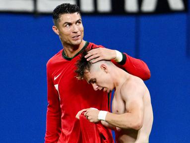 Pemain Portugal, Cristiano Ronaldo, memberikan selamat kepada Francisco Conceicao yang telah mencetak gol ke gawang Republik Ceko dalam duel matchday 1 Grup F Euro 2024, Rabu (19/6/2024). Portugal menang dengan skor 2-1. (AFP/Christophe Simon)