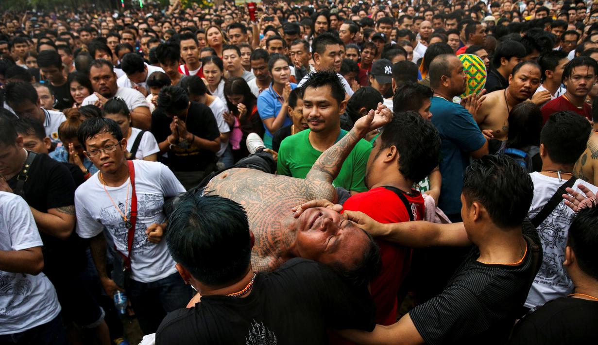 Seorang pria bertato terlihat kesurupan selama Festival Tato Suci di kuil Wat Bang Phra, Nakhon Pathom, Thailand (16/3). Mereka percaya tato memiliki kekuatan mistis, menangkal nasib buruk dan melindungi mereka dari bahaya. (Reuters/Athit Perawongmetha)