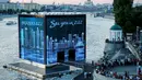 Warga melihat ke Majlis Qatar yang menyajikan pertunjukan cahaya di Gorky Park, Moskow, Rusia, Kamis (12/7). Qatar akan menjadi tuan rumah Piala Dunia 2022. (Maxim ZMEYEV/AFP)