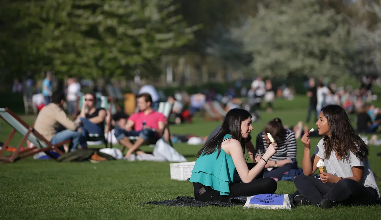 Memasuki musim dengan udara yang hangat membuat warga Inggris berbondong-bondong menikmati sinar matahari di taman-taman kota bersama keluarga atau teman, Inggris, Sabtu (8/4). (AFP PHOTO / Daniel Leal-Olivas)