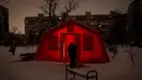 Seorang pria berada di luar tenda darurat tempat orang-orang dapat menghangatkan diri setelah serangan udara rutin Rusia terhadap fasilitas energi negara itu di tengah musim dingin, Kyiv, Ukraina, Selasa 13 Januari 2026. Militer Rusia kembali meluncurkan serangan udara besar-besaran ke Ukraina, Selasa (13/1/2026). (AP Photo/Danyil Bashakov)