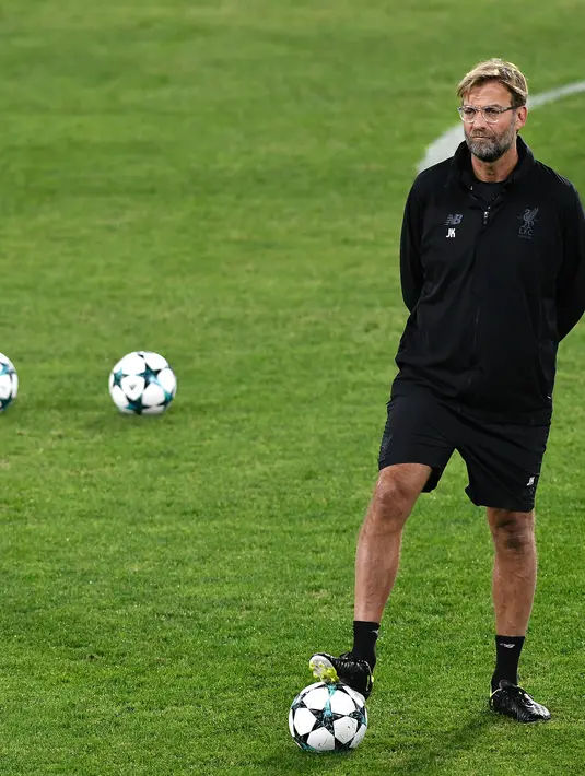 Pelatih Liverpool, Jurgen Kloop melihat para pemainnya berlatih di stadion Ramon Sanchez Pizjuan di Sevilla, Spanyol (20/11). Liverpool akan bertanding melawan Sevilla pada lanjutan grup E Liga Champions.  (AFP Photo/Cristina Quicler)