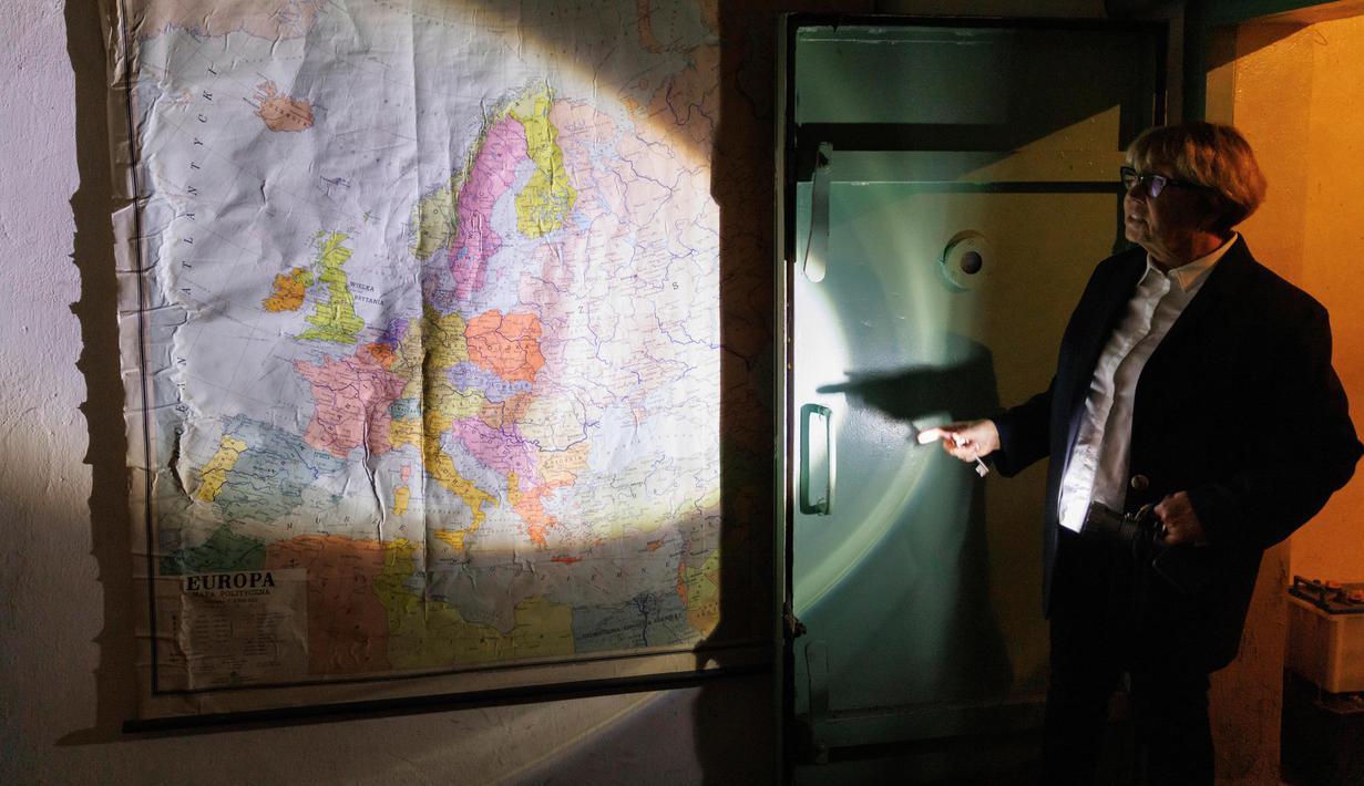 Juru bicara pabrik produksi baja ArcelorMittal Warsaw, Ewa Karpinska menunjukkan peta tua di tempat perlindungan Perang Dingin di bawah pabrik di Warsawa, Polandia, 20 Oktober 2022. Ketakutan akan penggunaan senjata nuklir pada perang Rusia dengan Ukraina terutama dirasakan oleh negara-negara dekat Ukraina, seperti Polandia. (AP Photo/Michal Dyjuk)