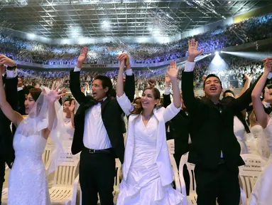 Sejumlah pasangan bergembira saat mengikuti pernikahan massal di Pusat Perdamaian Cheong Shim di Gapyeong, Korea Selatan, (7/9). Sebanyak 4.000 pasangan Korea Selatan dan asing ikut serta dalam acara ini. (AP Photo / Ahn Young-joon)