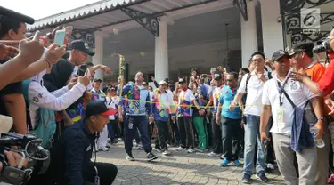 Gubernur DKI, Anies Baswedan membawa obor saat Pawai Obor Asian Para Games di Balai Kota DKI Jakarta, Minggu (30/9). Pawai obor dimulai dari Balai Kota dan berakhir di Gedung Kementerian Pemuda dan Olahraga (Kemenpora). (Liputan6.com/Herman Zakahria)