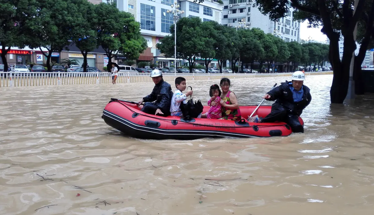 Petugas membantu warga melintasi banjir usai badai Topan Megi menghantam Kota Fuzhou di Provinsi Fujian, China, Rabu (28/9). Badai berkecepatan 120 Km/jam itu telah melumpuhkan aktivitas di Kota tersebut. (China Daily/via REUTERS)