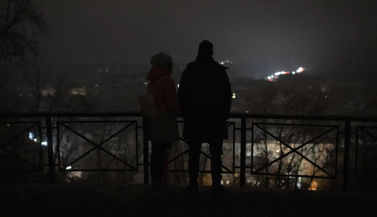 Orang-orang berdiri di tengah pemadaman listrik setelah serangan roket Rusia di Kiev, Ukraina, Rabu (23/11/2022). Wali Kota Kyiv, Vitali Klitschko, mengatakan setidaknya 80% penduduk ibu kota tidak memiliki pasokan listrik atau air ledeng. (AP Photo/Andrew Kravchenko)