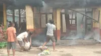 Warga di Kabupaten Indragiri Hilir bahu membahu memadamkan kebakaran sekolah. (Liputan6.com/M Syukur)