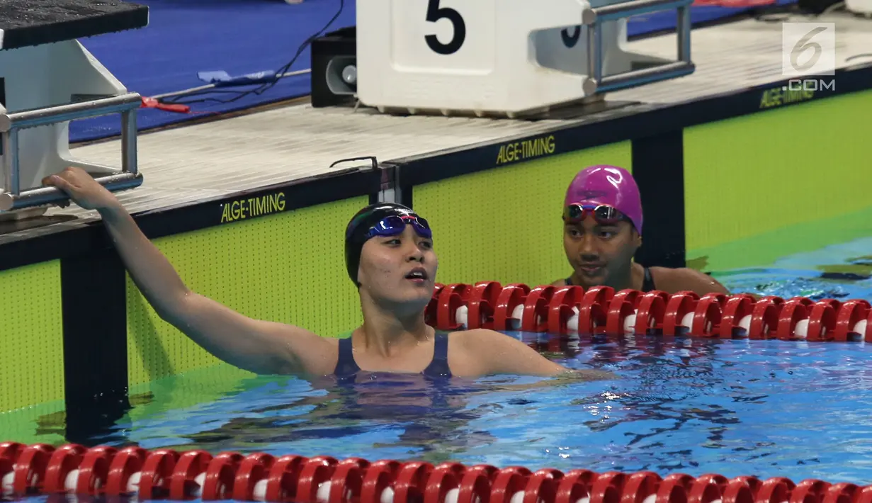 Atlet Indonesia, Syuci Indriani (kanan) mencapai finis saat final 100 meter gaya kupu-kupu putri S14 di Aquatic Center, Jakarta, Rabu (10/10). Syuci berhasil meraih mendali perak dengan catatan waktu 1 menit 11,08 detik. (Merdeka.com/Imam Buhori)