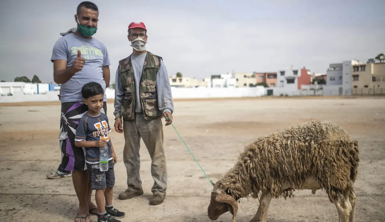 Keluarga berpose untuk foto setelah membeli seekor domba untuk perayaan Idul Adha di sebuah pasar di pinggiran Rabat, Maroko, Kamis (30/7/2020). (AP Photo/Mosaab Elshamy)
