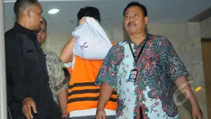 Direktur PT Mitra Maju Sukses, Andrew Hidayat menutup wajahnya usai menjalani pemeriksaan di Gedung KPK, Jakarta, Sabtu (11/4/2015), dini hari. Andrew ditangkap KPK bersama barang bukti uang senilai  US$ 90.000. (Liputan6.com/Herman Zakharia)