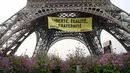 Sebuah spanduk bertuliskan "Kebebasan, Kesetaraan, Persaudaraan" terpampang di Menara Eiffel di Paris, Prancis, Kamis (5/5). (AFP/Jacques DEMARTHON)