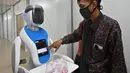 Teknisi melakukan input pada robot Amy saat simulasi membantu petugas medis dalam menangani pasien virus corona COVID-19 di Rumah Sakit Pertamina Jaya (RSPJ), Jakarta, Kamis (16/4/2020). Amy akan digunakan untuk membawa makanan, obat, dan segala kelengkapan lain untuk pasien. (ADEK BERRY/AFP)