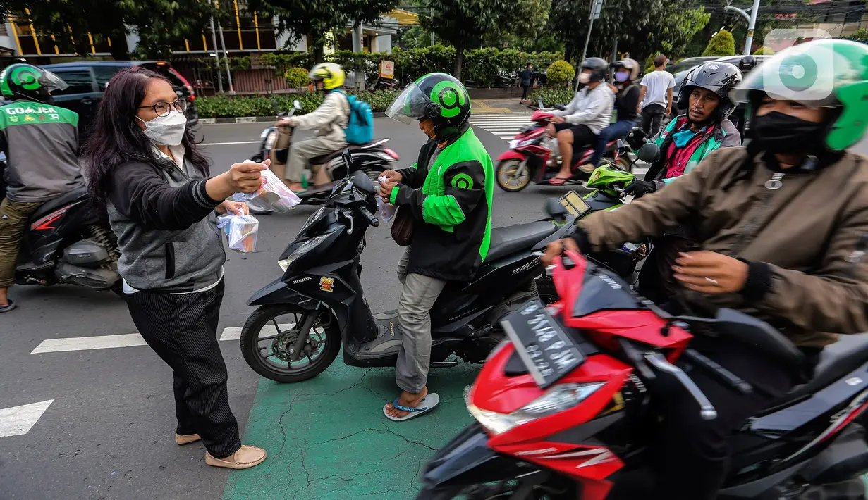 Jemaat membagikan takjil kepada masyarakat menjelang buka puasa di Gereja GPIB Effatha, Jakarta, Rabu (20/4/2022). Momen menjelang buka puasa Ramadhan digunakan jemaat GPIB Effatha berbagi takjil gratis untuk kaum Muslimin di Jalan Melawai, tepatnya di depan gereja itu. (Liputan6.com/Johan Tallo)