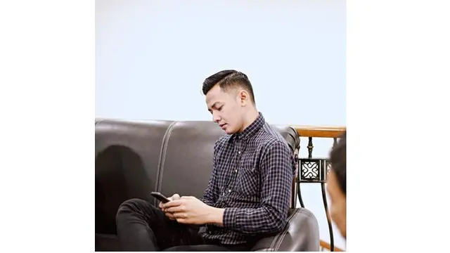 Berpose serius saat melihat layar handphone, Dory Harsa terlihat makin ganteng.