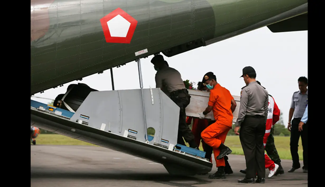Polisi dan anggota basarnas membawa peti jenazah penumpang pesawat AirAsia QZ8501 ke dalam kapal pesawat CN2950 milik Angkatan Udara Indonesia di Pangkalan Udara Iskandar, Pangkalan Bun, Kalteng, (19/1/2015). (REUTERS / Beawiharta)