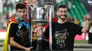 Dua pemain Valencia berpose dengan trofi Copa Del Rey usai pertandingan melawan Barcelona pada babak final di stadion Benito Villamarin di Seville, Spanyol (25/5/2019). Barcelona kalah 1-2 dari Valencia lewat gol Kevin Gameiro dan Rodrigo. (AP Photo/Miguel Morenatti)