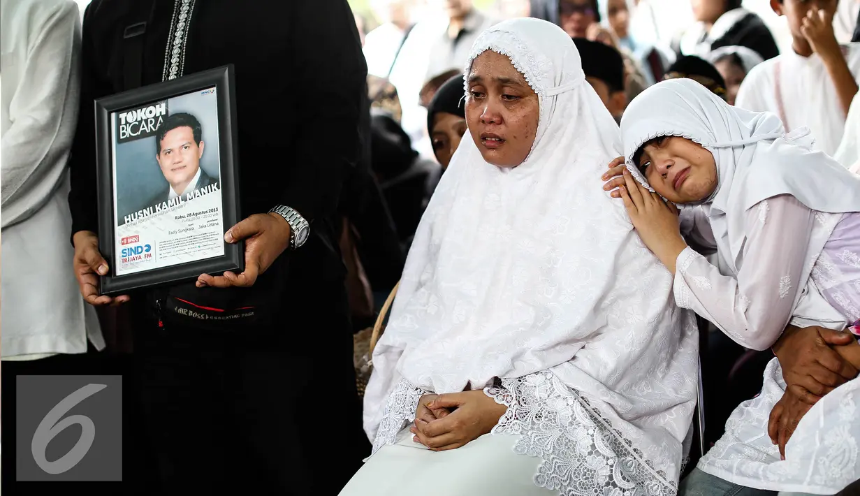 Istri Alm Husni Kamil Malik bersama anak perempuan berdoa pemakaman Alm Husni Kamil Malik  di TPU Jeruk Purut, Jakarta, Rabu (8/7). Husni Kamil Manik meninggal semalam saat menjalani perawatan di RS Pusat Pertamina. (Liputan6.com/Faizal Fanani)