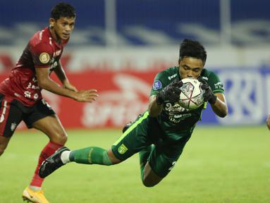 Kiper Persebaya Surabaya, Ernando Ari Sutaryadi, tampi bagaikan tembok kukuh saat melawan Bali United pada pekan ke-33 BRI Liga 1 2021/2022 di Stadion I Gusti Ngurah Rai, Denpasar, Jumat (25/3/2022). (Bola.com/M Iqbal Ichsan)