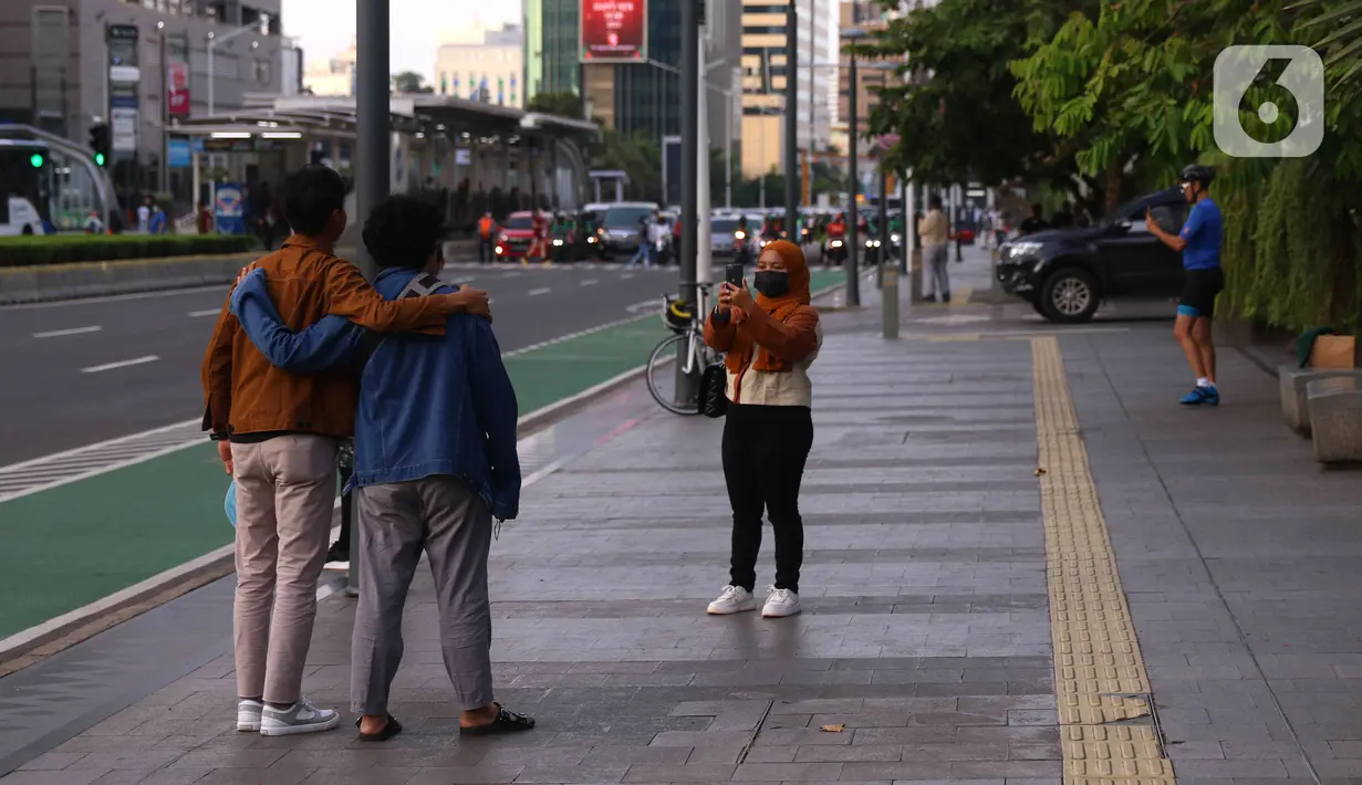Aktivitas warga saat berada di kawasan Bundaran HI, Jakarta, Jumat (31/12/2021). Polda Metro Jaya melarang perayaan malam tahun baru 2022 di seluruh wilayah DKI Jakarta. Kebijakan itu berlaku mulai 31 Desember 2021 hingga 2 Januari 2022. (Liputan6.com/Angga Yuniar)