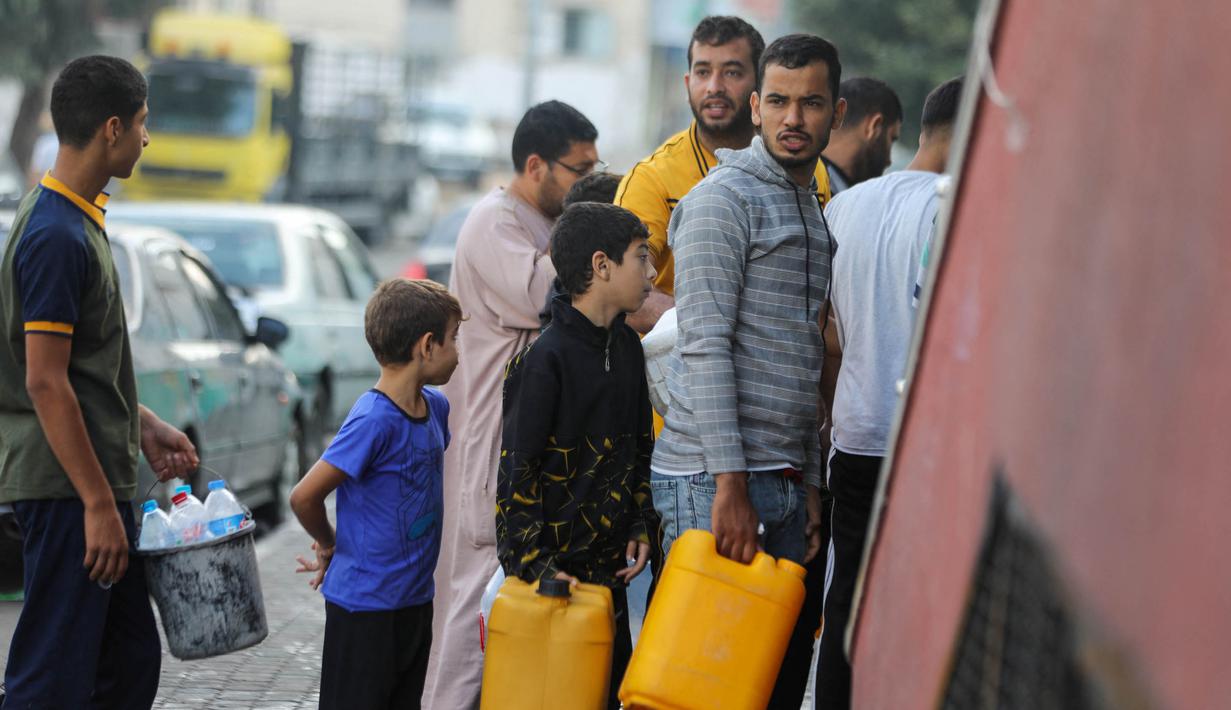 Warga Palestina mengantre untuk mengisi tabung air di Kota Gaza, pada 16 Oktober 2023. (Dawood NEMER/AFP)