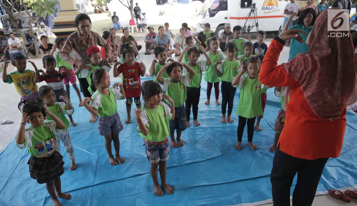 Anak-anak TK menari di kamp pengungsian Gor Swace Pura, Klungkung, Bali, Kamis (28/09). Kegiatan tersebut bertujuan menghilangkan rasa trauma serta sebagai sarana bermain anak korban bencana alam. (Liputan6.com/Gempur M Surya)
