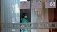Seorang wanita yang mengenakan masker terliat di Posko Ante Mortem-DVI RS Polri Jakarta, Selasa (12/1/2021). Hingga saat ini, tim DVI masih mengumpulkan sampel DNA penumpang pesawat Sriwijaya Air SJ 182 yang jatuh di perairan Kepualauan Seribu. (merdeka.com/Imam Buhori)