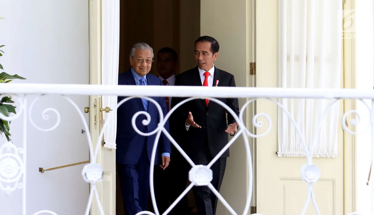 Presiden Joko WIdodo (Jokowi) dan PM Malaysia, Mahathir Mohamad berjalan menuju beranda Istana Bogor, Jumat (29/6). Kedua pemimpin negara tersebut melakukan pertemuan untuk membahas ekonomi, sosial budaya dan tenaga kerja. (Liputan6.com/Angga Yuniar)