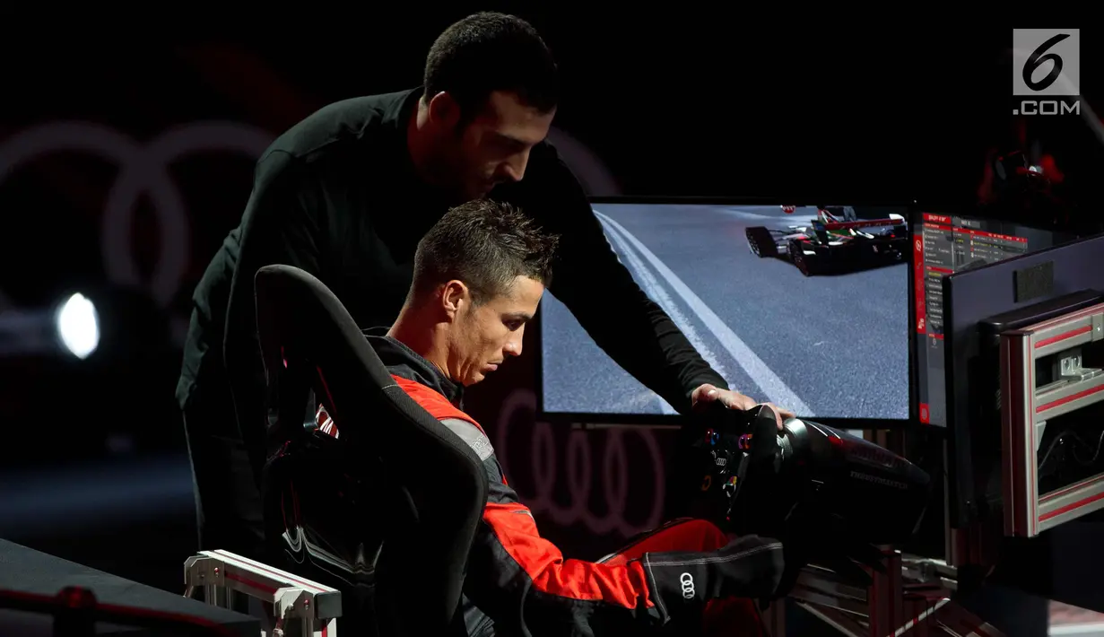 Penyerang Real Madrid, Cristiano Ronaldo bersiap untuk balapan di simulator Formula E selama sebuah acara promosi di Madrid, Spanyol, (23/11). (AP Photo / Paul White)