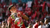 Bek Manchester United (MU) asal Argentina, Lisandro Martinez, mengangkat trofi juara Piala FA setelah kemenangan 2-1 yang diraih The Red Devils atas Man City di final Piala FA yang digelar di Wembley, Sabtu (25/5/2024). (Ben Stansall / AFP)