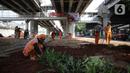 Sejumlah petugas PPSU menanam pohon di kolong Tol Becakayu, Jakarta, Kamis (12/1/2023). Pemerintah Provinsi DKI Jakarta melakukan penataan lahan melalui program penghijauan sepanjang lima kilometer di tepi saluran Kalimalang  kolong tol Bekasi Cawang Kampung Melayu (Becakayu), Jakarta Timur untuk menjaga mutu air baku Jakarta. (Liputan6.com/Faizal Fanani)