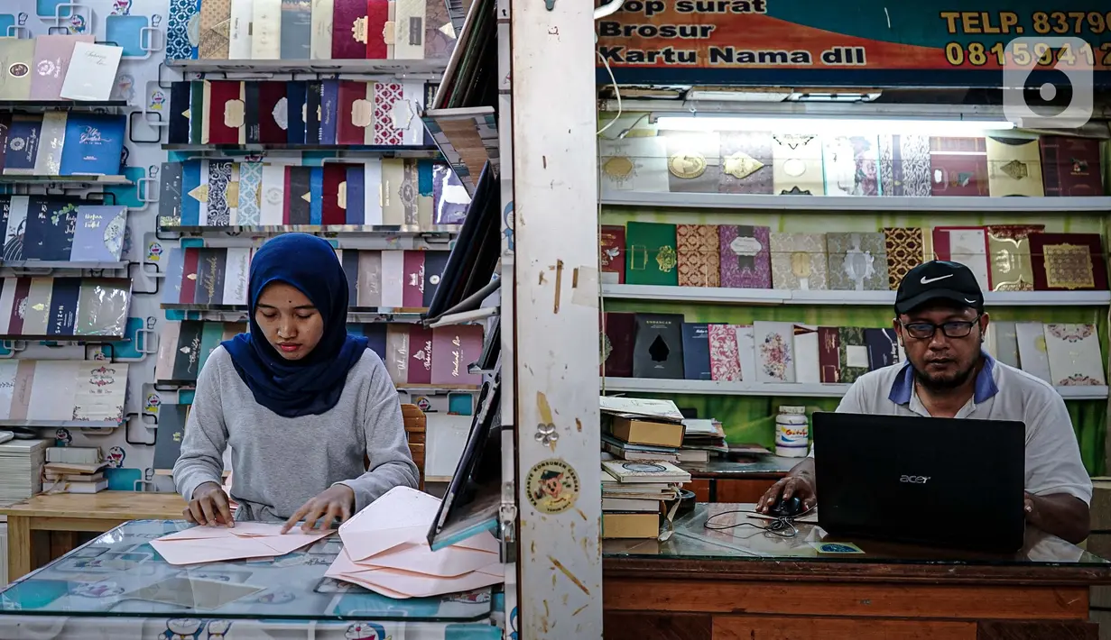 Aktivitas pedagang kertas undangan pernikahan di Pasar Tebet, Jakarta, Kamis (22/7/2020). Adanya larangan saat pandemi covid-19 untuk mengadakan acara yang bisa menimbulkan kerumunan, seperti pesta pernikahan, menyebabkan pendapatan usaha percetakan ini turun drastis. (Liputan6.com/Faizal Fanani)