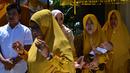 Tokoh adat dan agama menggendong bayi pada ritual 'peutron tanoh aneuk' (turun tanah anak) di Banda Aceh, Aceh, Senin (15/7/2019). Ritual turun tanah anak yang telah menjadi tradisi sakral bagi masyarakat Aceh yang dilaksanakan pada saat bayi berusia 44 hari. (CHAIDEER MAHYUDDIN / AFP)