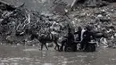 Data Kementerian Kesehatan di Gaza yang dikelola Hamas menyebut, hingga Rabu 26 November 2025, serangan Israel di Gaza telah menewaskan sedikitnya 69.775 orang. Tampak dalam foto, orang-orang menunggangi kereta kuda melewati banjir di kamp darurat yang menampung warga Palestina yang terlantar setelah hujan deras di Kota Gaza pada Selasa 25 November 2025. (Omar AL-QATTAA/AFP)