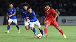 Striker Timnas Indonesia U-22, Irfan Jauhari menguasai bola dibayangi pemain Kamboja, Taing Bunchhai pada laga keempat Grup A SEA Games 2023 di Olympic National Stadium, Phnom Penh, Kamboja, Rabu (10/5/2023). (Bola.com/Abdul Aziz)