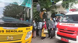 Sejumlah pasien Covid-19 Tanpa Gejala saat memasuki bus sekolah di Puskesmas Kecamatan Cilandak, Jakarta, Kamis (4/2/2021). Sehingga total kasus positif bertambah menjadi 1.123.105 orang. (Liputan6.com/Herman Zakharia)