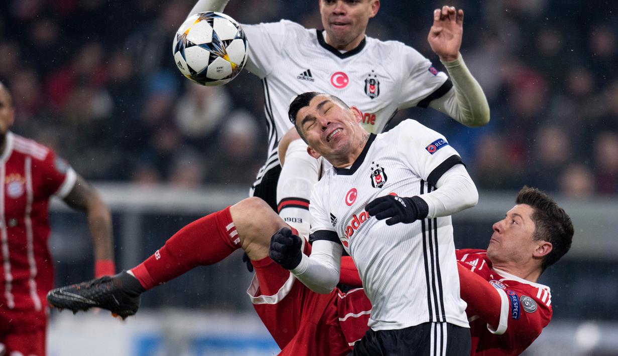 Pemain Bayern Munchen, Robert Lewandowski berebut bola dengan pemain Besiktas, Gary Alexis Medel dan Pepe pada leg pertama babak 16 besar Liga Champions di Allianz Arena, Selasa (20/2). Bayern melumat Besiktas lima gol tanpa balas. (Sven Hoppe/dpa via AP)
