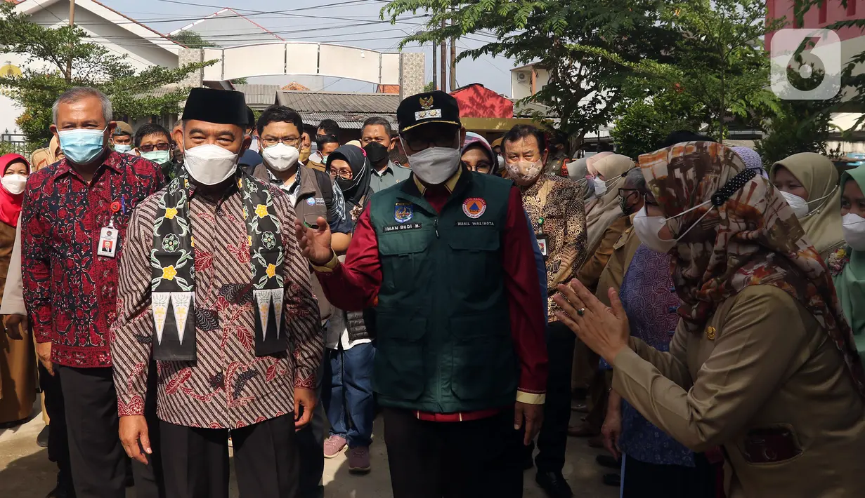 Menko PMK Muhadjir Effendy (depan kiri) tiba untuk meninjau vaksinasi COVID-19 di SDN 01 Depok, Depok, Jawa Barat, Selasa (14/12/2021). Kunjungan tersebut untuk melihat persiapan vaksinasi COVID-19 anak usia 6-11 tahun yang dilaksanakan mulai hari ini. (Liputan6.com/Herman Zakharia)