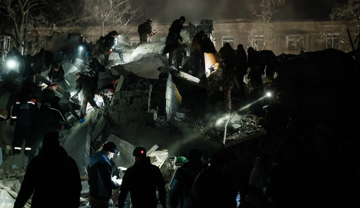 <p>Tim penyelamat memindahkan puing-puing untuk mencari korban selamat di gedung apartemen yang hancur terkena roket pada malam hari di pusat kota Kramatorsk, Ukraina timur, pada Rabu (1/2/2023). Kepolisian wilayah Donetsk dalam pernyataan terpisah menyebut lebih dari 100 polisi dikerahkan untuk membantu operasi penyelamatan di lokasi gedung yang hancur. (Yasuyoshi CHIBA / AFP)</p>