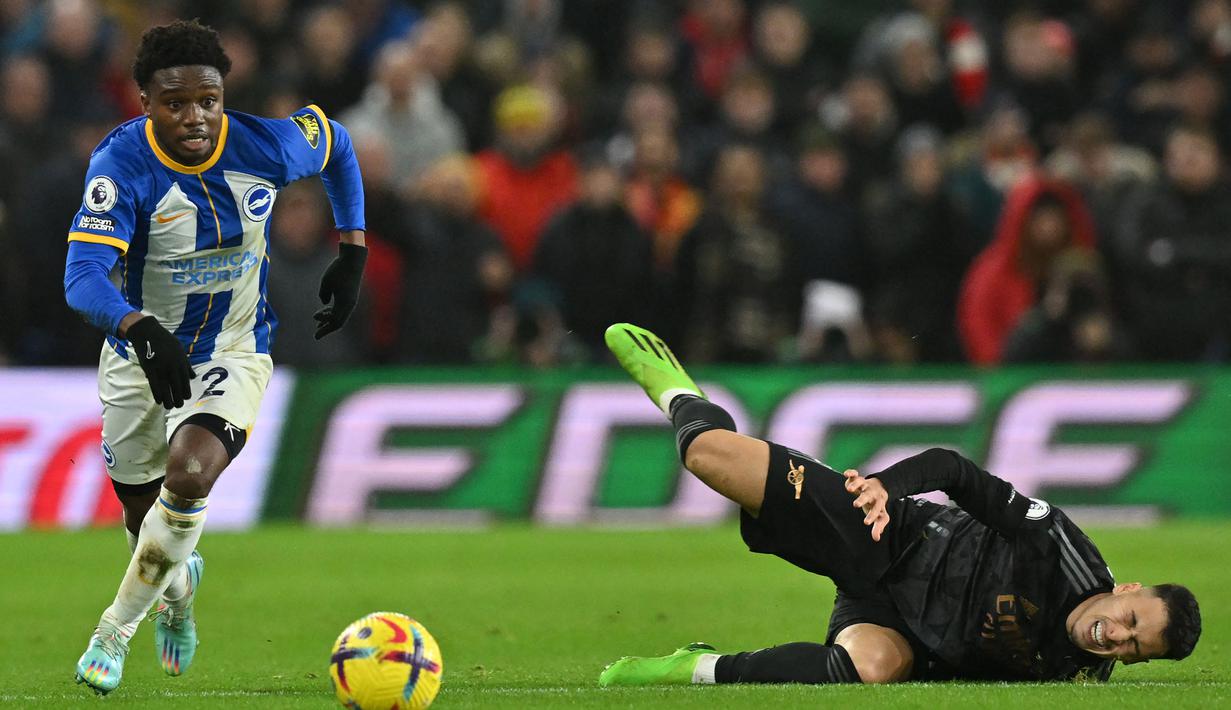 Gelandang Brighton abd Hove Albion, Tariq Lamptey berusaha melewati gelandang Arsenal, Gabriel Martinelli pada laga Liga Inggris 2022/2023 di American Express Community Stadium, Brighton (31/12/2022). Tariq Lamptey didatangkan Brighton and Hove Albion pada paruh musim 2019/2020 dari Chelsea dengan nilai transfer hanya 1,2 juta euro dan masih menyisakan kontrak dua tahun lagi. Crystal Palace dan Chelsea menjadi dua klub yang dibelanya sepanjang kariernya. (AFP/Glyn Kirk)