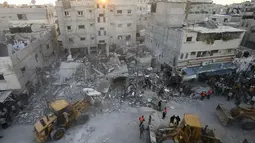 Beberapa alat berat digunakan tim penyelamat Palestina untuk membersihkan sisa bangunan yang runtuh akibat serangan militer Israel di kota Rafah, (11/7/2014). (REUTERS/Ibraheem Abu Mustafa)