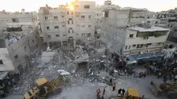 Beberapa alat berat digunakan tim penyelamat Palestina untuk membersihkan sisa bangunan yang runtuh akibat serangan militer Israel di kota Rafah, (11/7/2014). (REUTERS/Ibraheem Abu Mustafa)