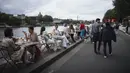 Orang-orang duduk di teras tepi Sungai Seine, Paris, Prancis, Minggu (11/7/2021). Prancis telah mengakhiri kewajiban mengenakan masker di luar ruangan dan pencabutan jam malam sejak pertengahan Juni lalu menyusul penurunan kasus COVID-19. (AP Photo/Lewis Joly)