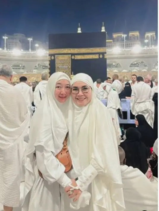 Momen umrah bersama pun terulang kembali tahun ini. Setelah anak mereka resmi bertunangan, Umi Kalsum dan besannya itu berbahagia datang ke Tanah Suci lagi. Kedua ibu ini juga terlihat awet muda dalam balutan busana muslim syar'i serba putih dan wajah polos tanpa makeup. (Liputan6.com/IG/@mom_ayting92_)